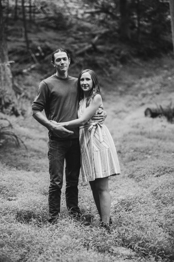 A black and white photo of a couple embracing in the woods during an engagement session in PA