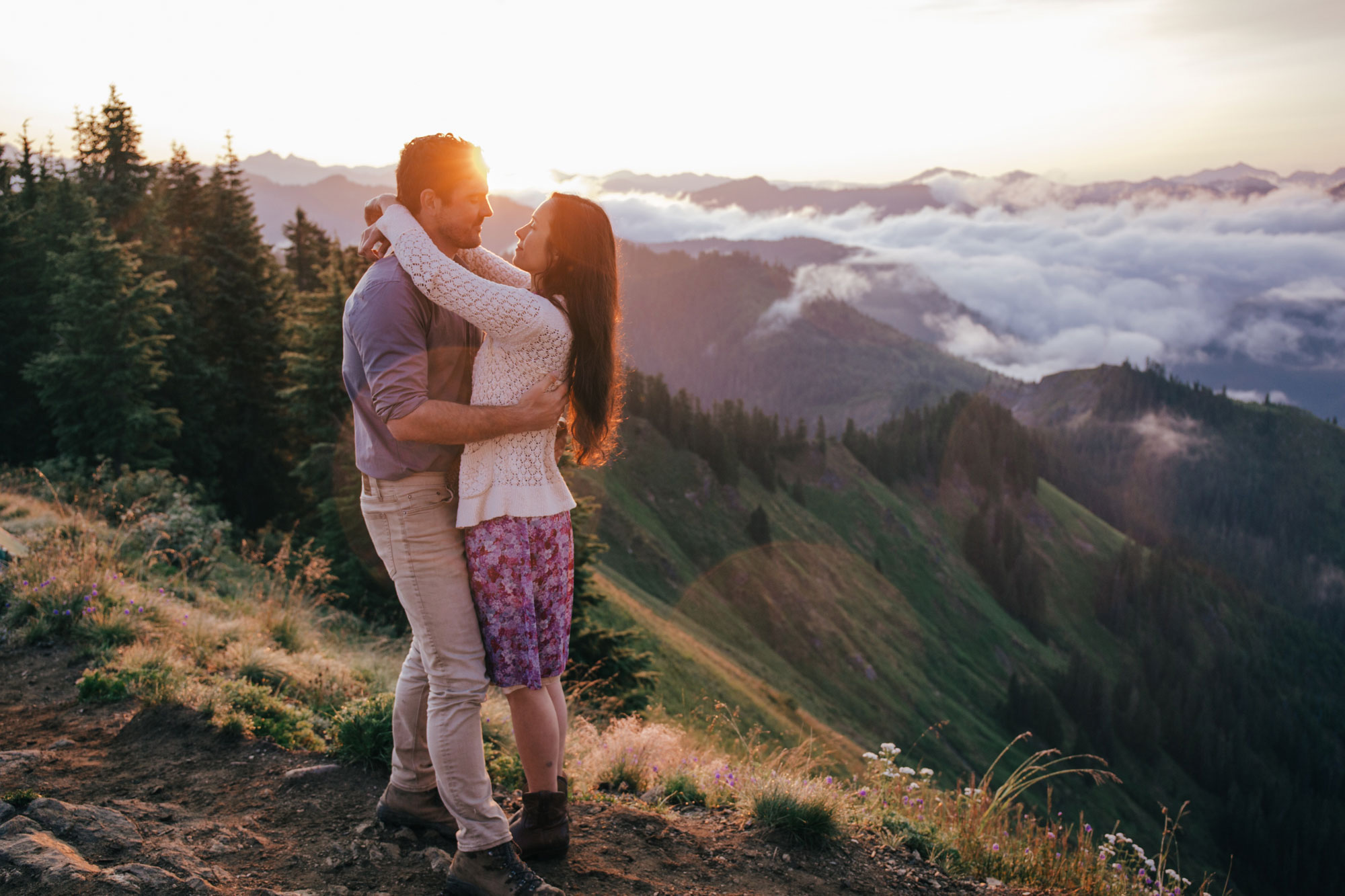An adventurous couple embracing during sunrise atop of Evergreen Mountain near Seattle Washington