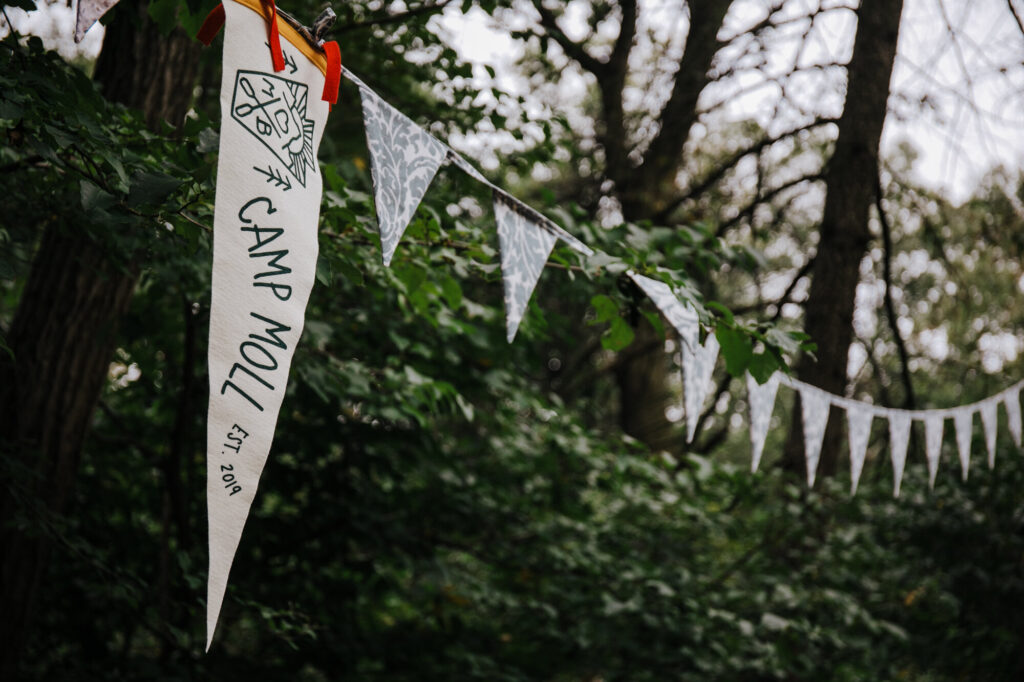 A custom pennant banner with a large custom flag hanging in the trees