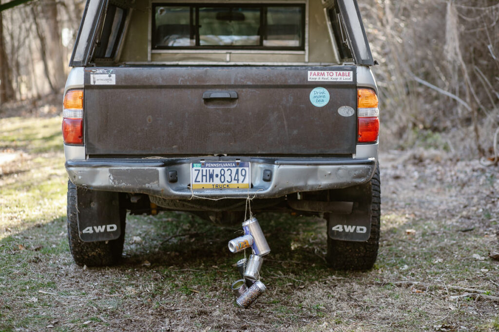 A toyota Tacoma with cans tied on the back for a wedding day