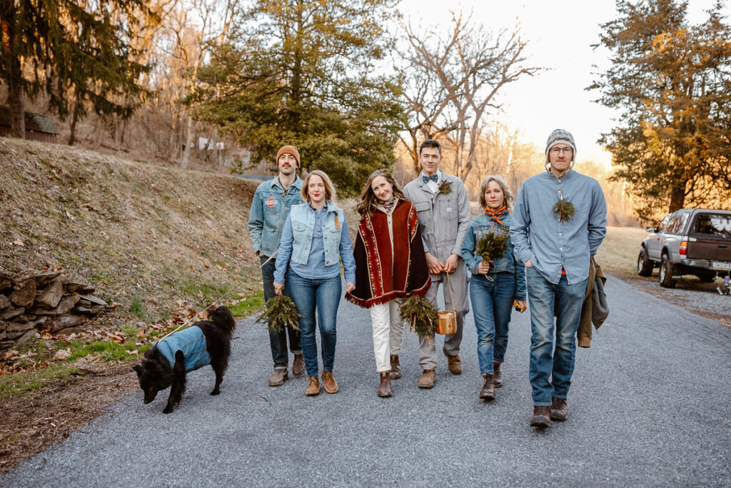 A wedding party dressed in all denim, is walking down on a backroad on the way to their reception