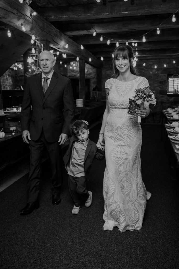 Bride walks with her son and father down the aisle on her wedding day