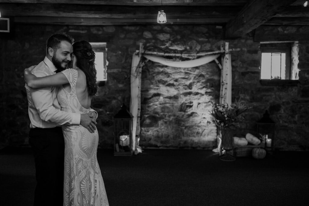 A newly married couple during their first dance. They are in front of the alter from their intimate ceremony