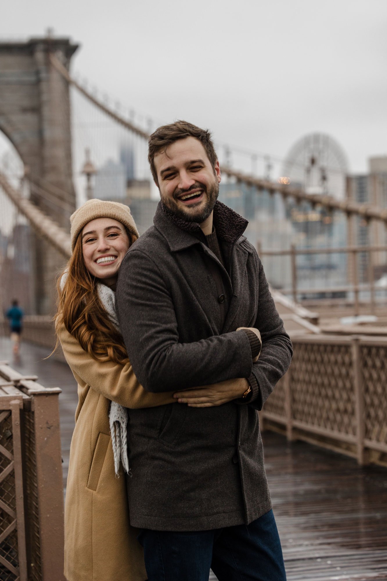Couple posing for a photo on the Brooklyn Bridge