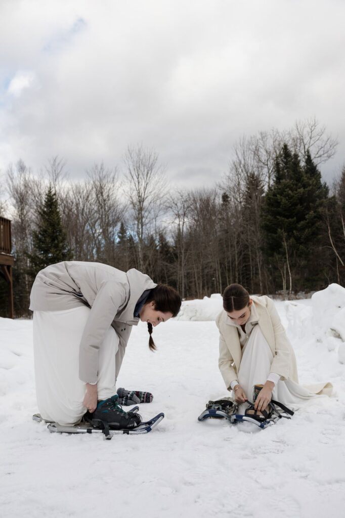 A couple put on their snow shoes to hike to their ceremony site in the snow.