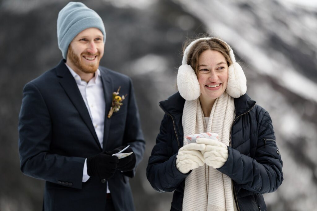 A birde sand groom hold Hot Hands hand warmers during their chilly winter hiking elopement