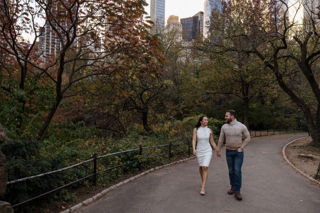 A couple walks while holding hands in Central Park