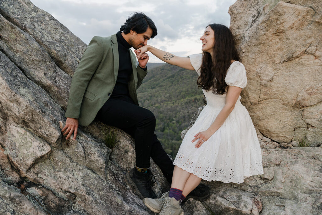 A groom kisses his brides hand while at their elopement in Shenandoah National Park