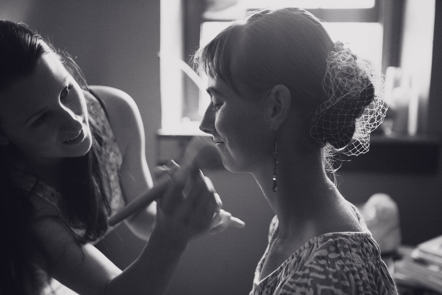 A bride getting her makeup done on her wedding day