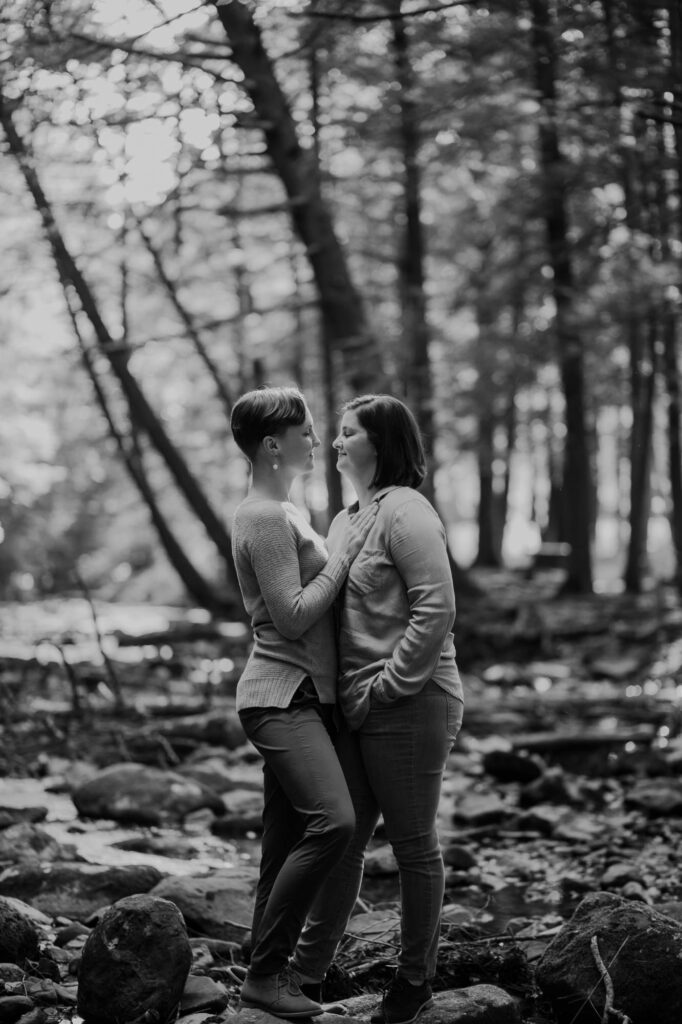 black and white photo of a same sex couple looking into one another's eyes 
