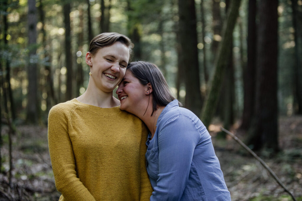 A same sex couple laughing during their engagement session
