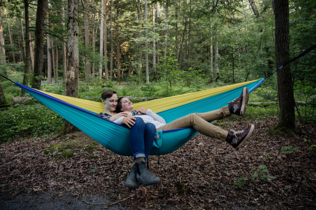 same sex couple snuggling in a hammock 