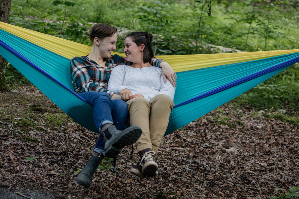 same sex couple snuggling in a hammock during their Pennsylvania State Park Engagement session
