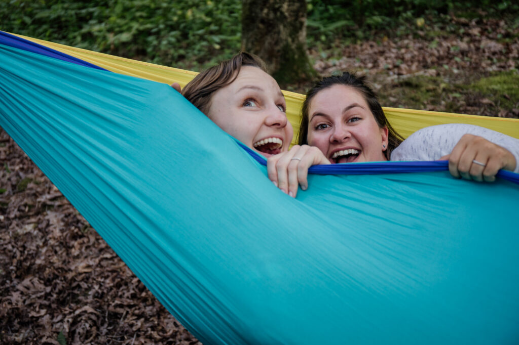 same sex couple being silly in  a hammock during their engagement session