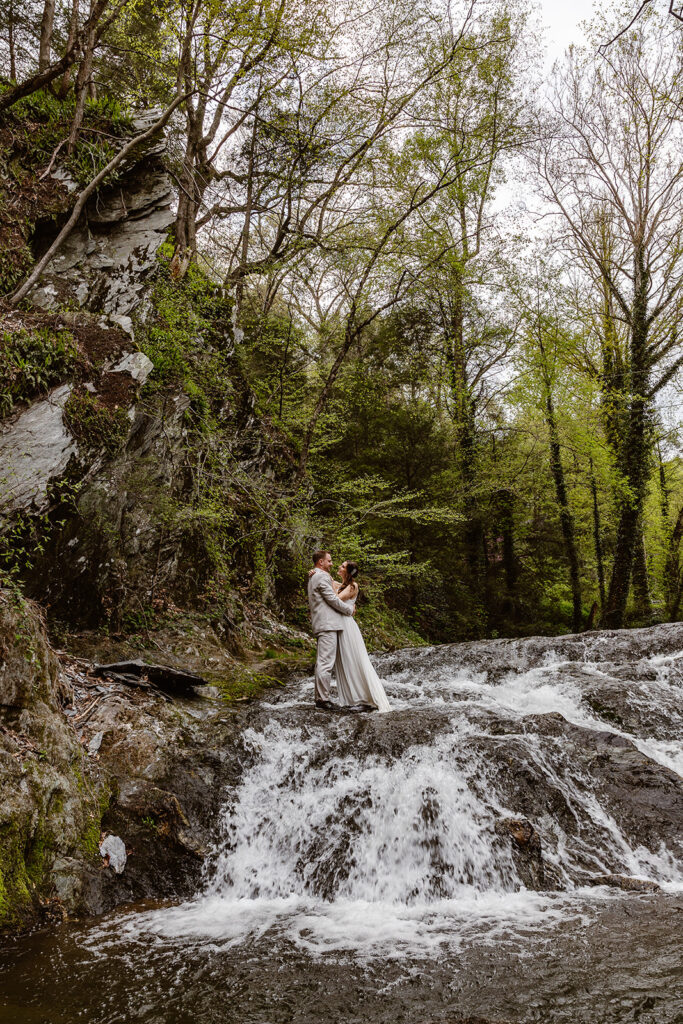 Couple posing in a Pennsylvania waterfall during their elopement
