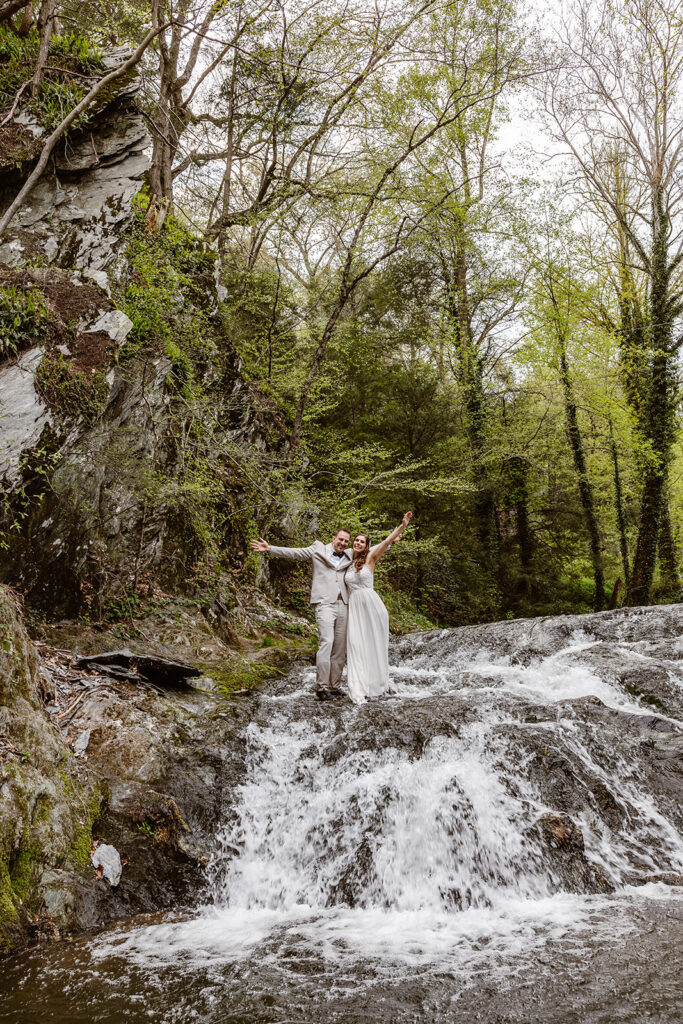 married couple celebrating in a waterfall during their Pennsylvania elopement