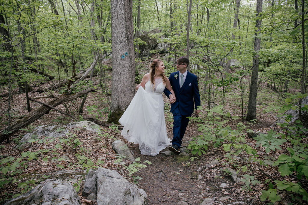 A couple holding hands and walking along a trail 