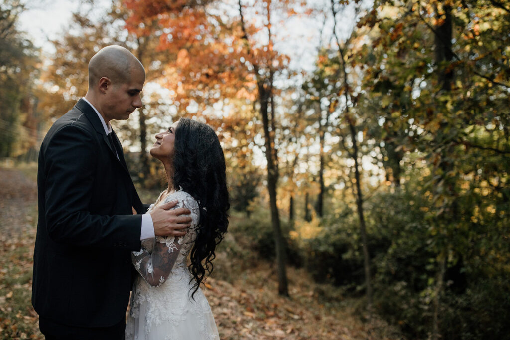 A couple with their arms around each other smiling 
