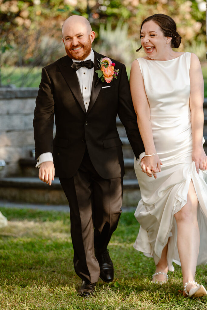 A couple is announced during their intimate wedding. They are holding hands, and beaming with joy. 