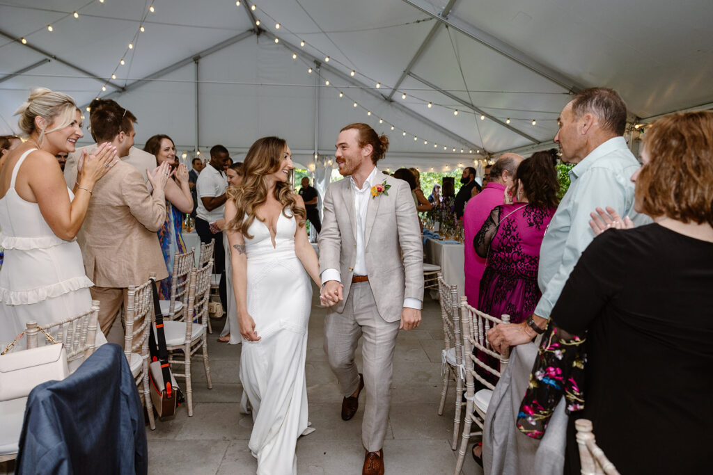 The bride and Groom entering the reception tent as they are being introduced