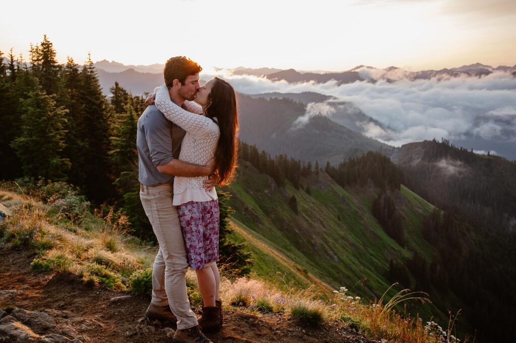 A couple embraces at the top of a mountain during their elopement at sunrise