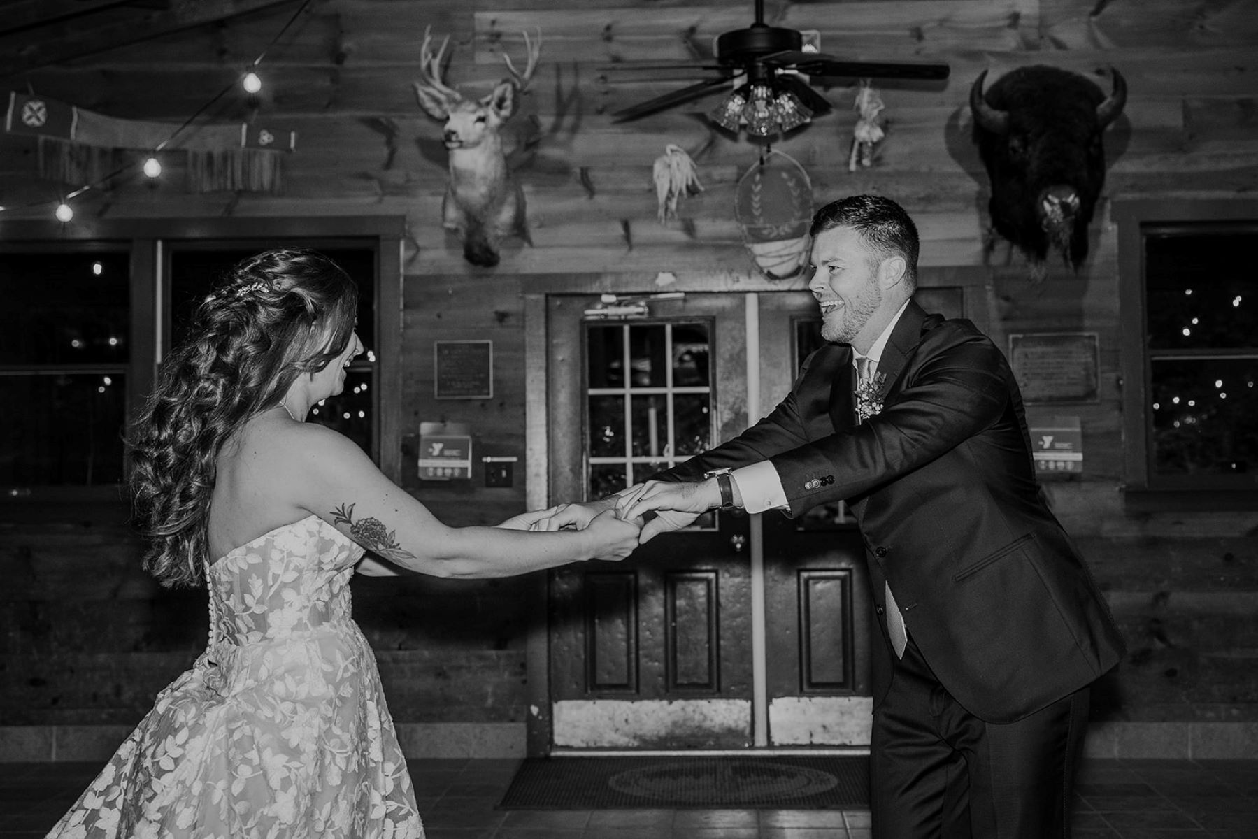 A couple dancing in a lodge at their wedding ceremony together 