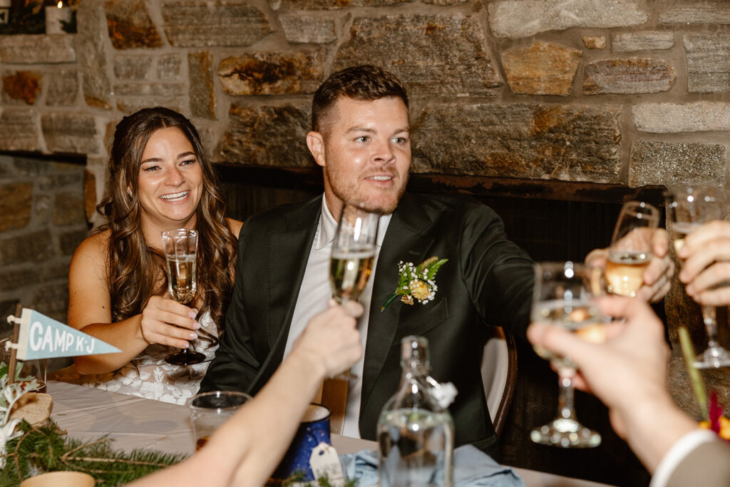 A bride and groom raise their glasses during a toast at their wedding reception