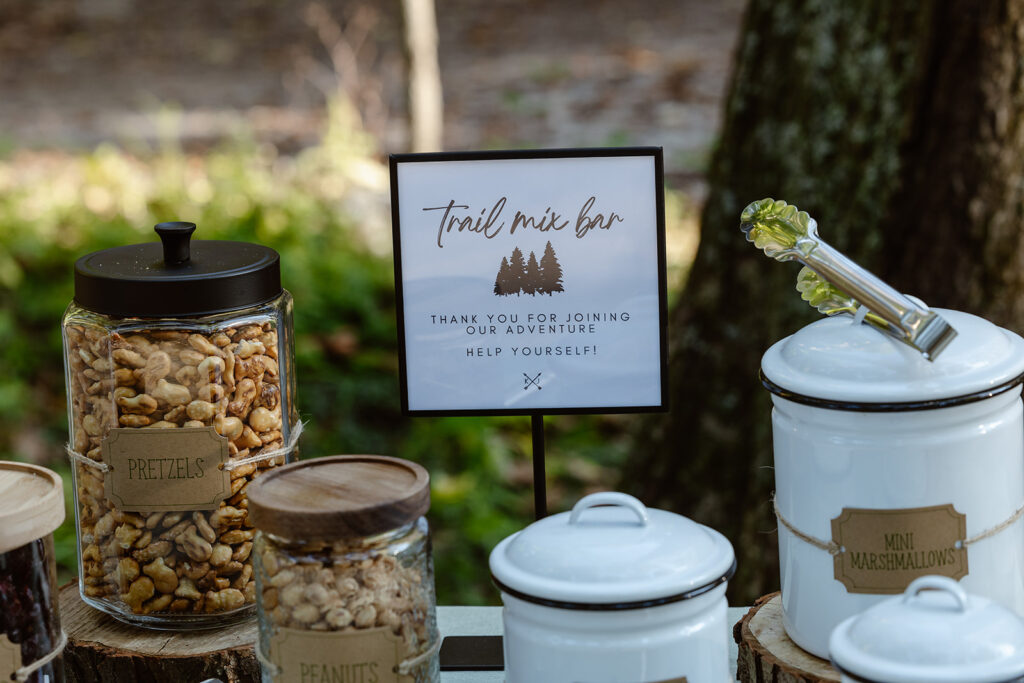 A photo of a trail mix bar. There are different containers filled with nuts and things you would add to trail mix