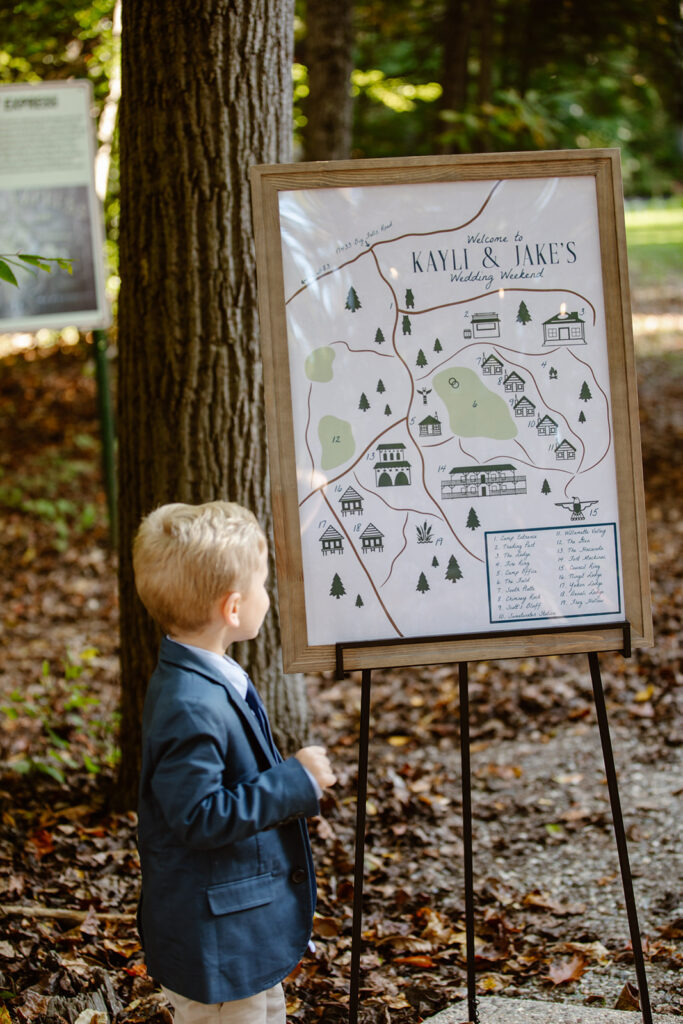 A little boy is looking at the map of the campground for the wedding day. camp puh'tok wedding