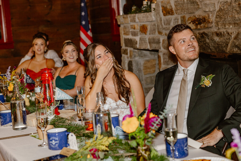 A bride and groom intently listening to a toast on their wedding day