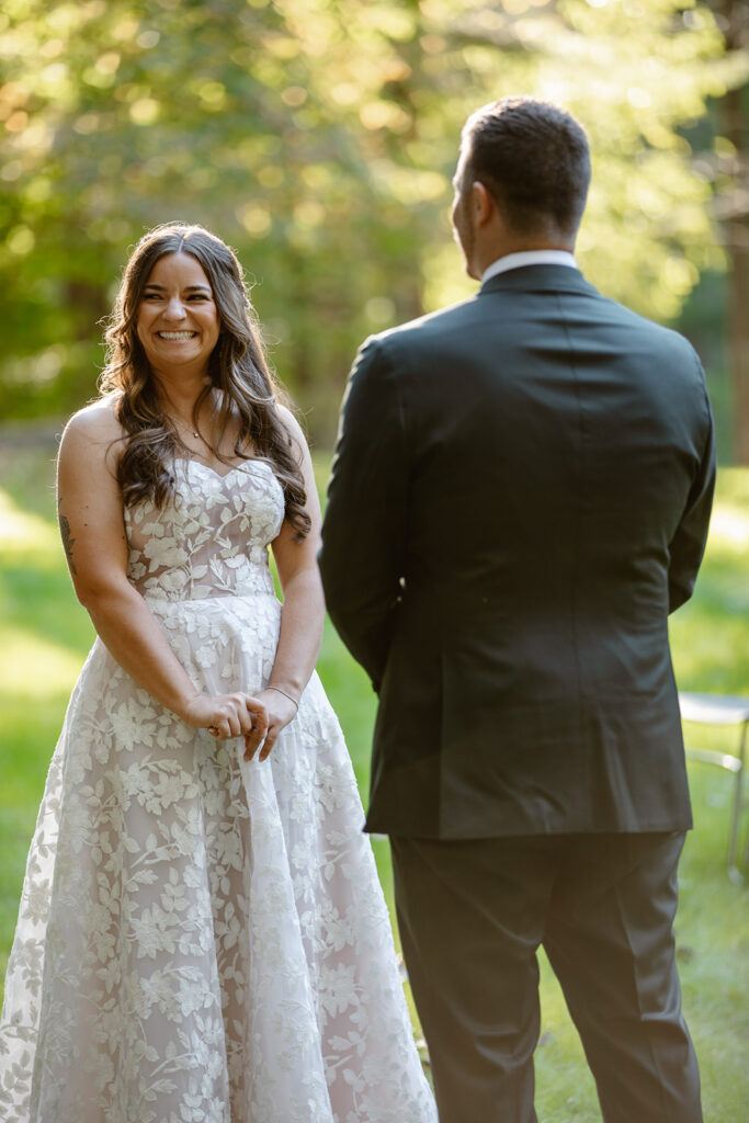 A bride looks at the officiant while laughing during her wedding ceremony