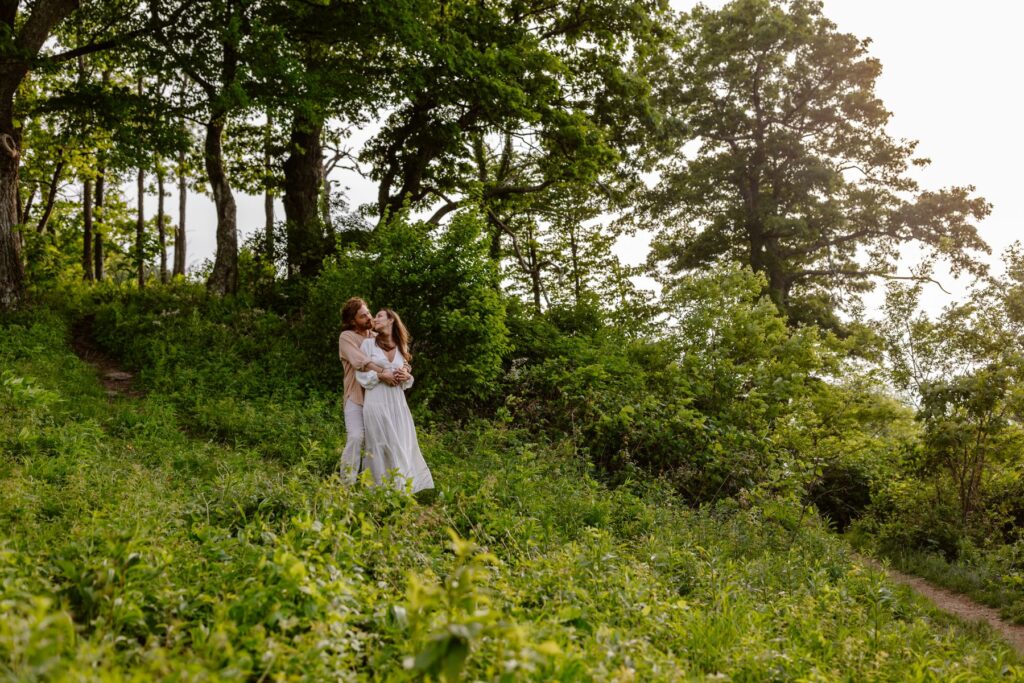 A couple embraces in the lush green forest