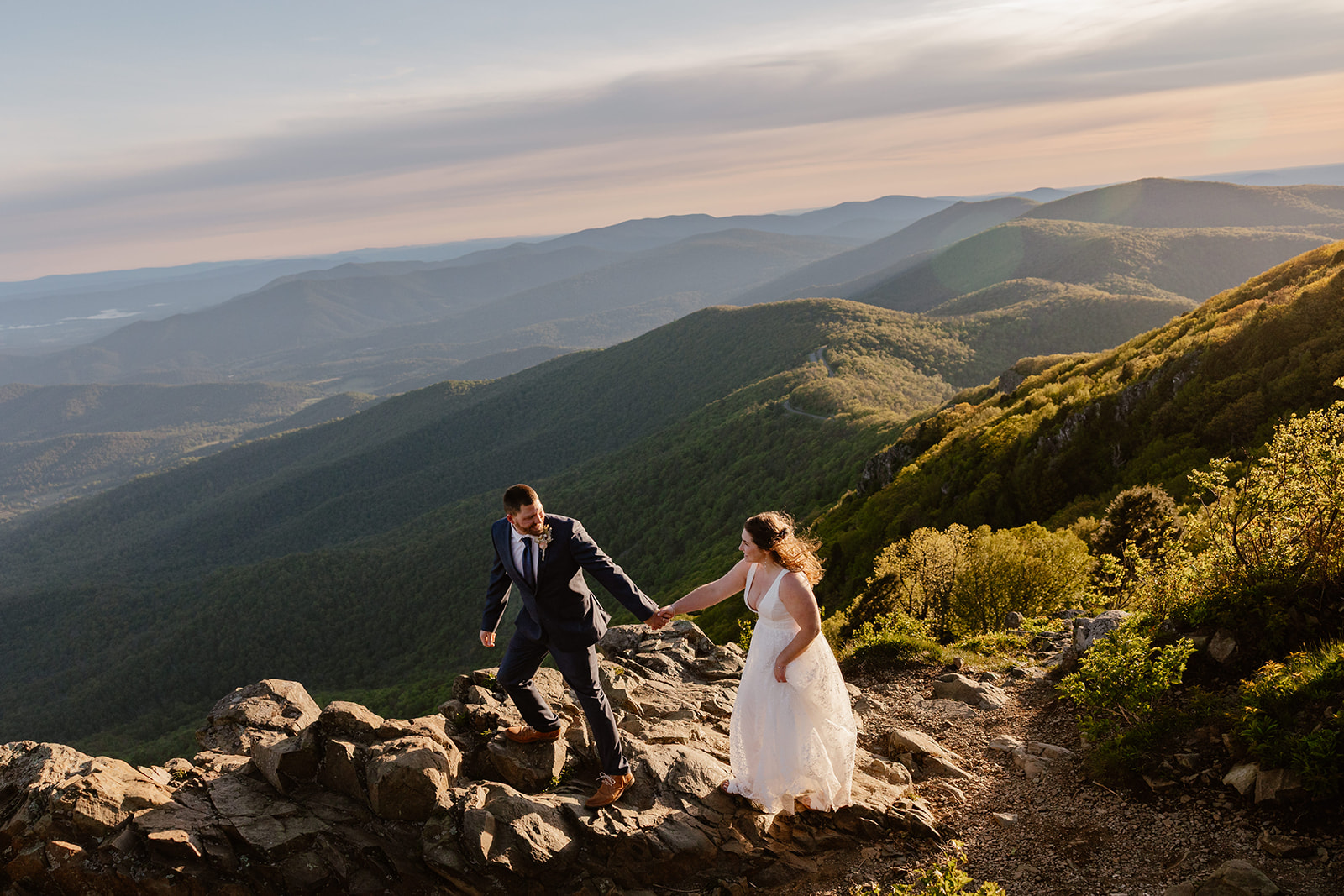 A couple standing atop Stony Man in Virginia at sunrise during their elopement