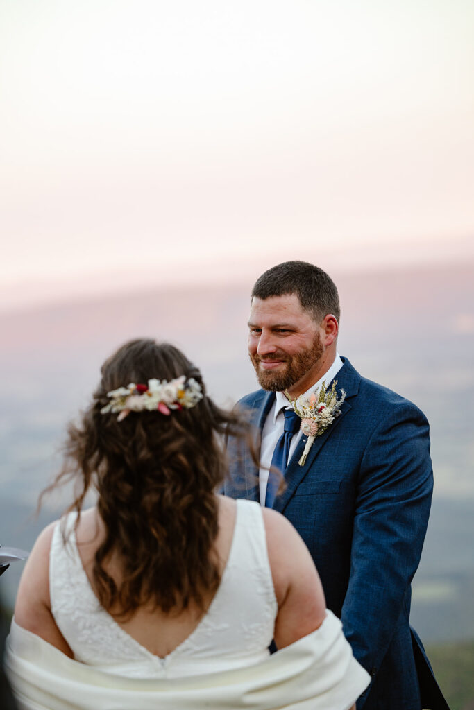 A groom looks at his bride to be during the vows of their wedding ceremony