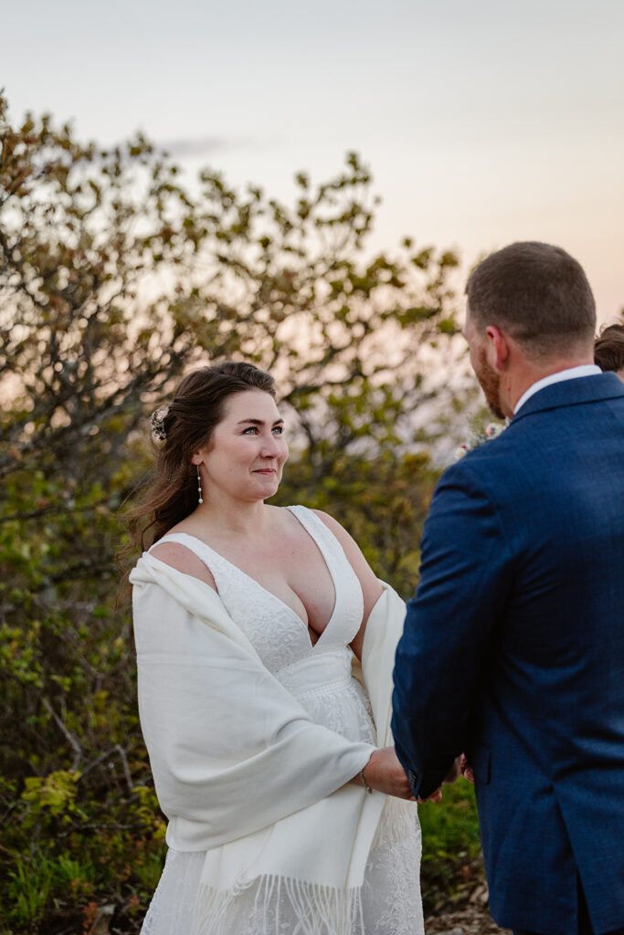 A bride looks at her her husband to be lovingly during the vows of their wedding ceremony.