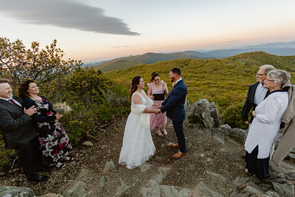 A bride and groom surrounded by their parents at Shenandoah National Park during their sunrise elopement