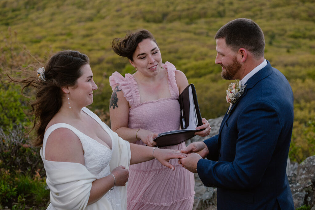 A groom puts a ring on his brides finger during their wedding ceremony