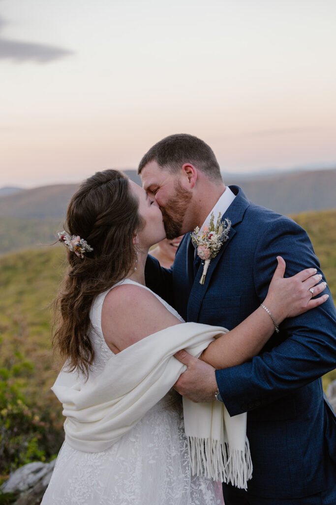A bride and groom kiss for the first time on their wedding day