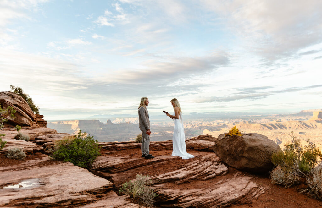 A bride and groom exchanging vows at Dead Horse State Park during their sunrise elopement.