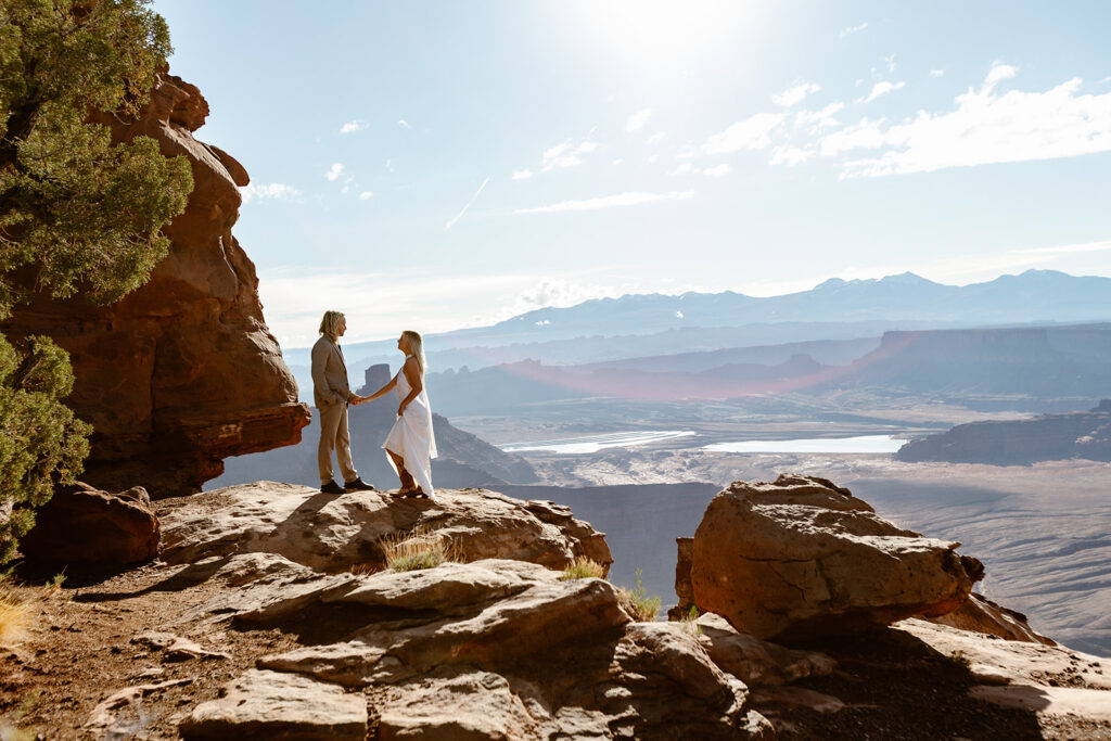 A couple holds hands at Dead Horse State Park during their sunrise elopement in Moab