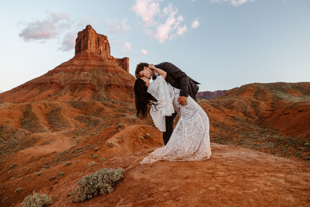 A couple does a dip after they say "I do" in the Moab desert.
