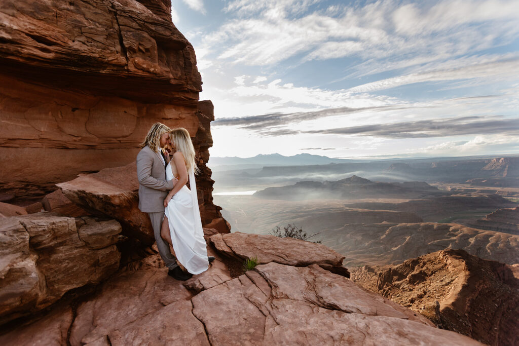 A couple holds hands at Dead Horse State Park during their sunrise elopement in Moab