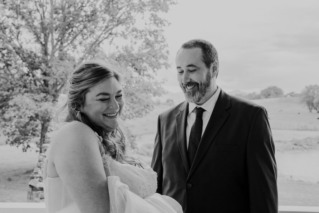 A groom looks at his bride for the first time on the micro wedding day. They are both smiling 