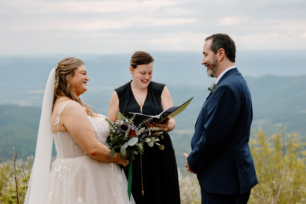 A bride, groom, and officiant during the couples wedding ceremony at an overlook in Virginia. 