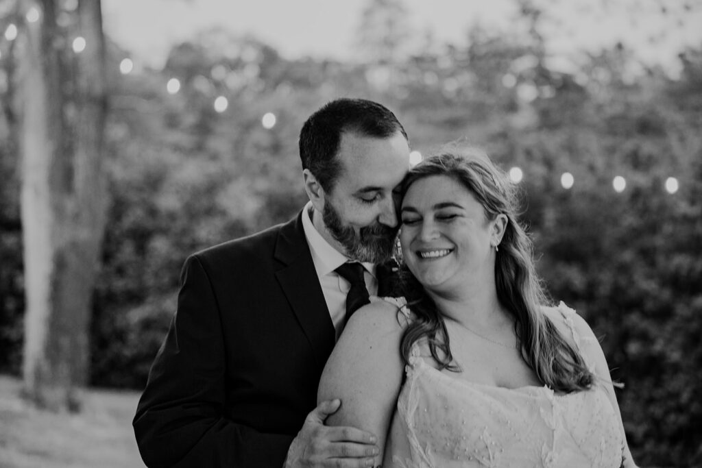 A groom nuzzles into his brides cheek in a portrait of the couple on their wedding day. 