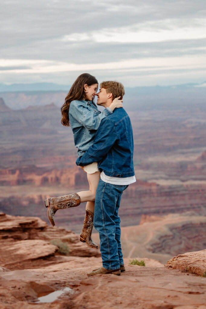 A groom picks up his wife during a photo session any Dead Horse State Park in Moab.