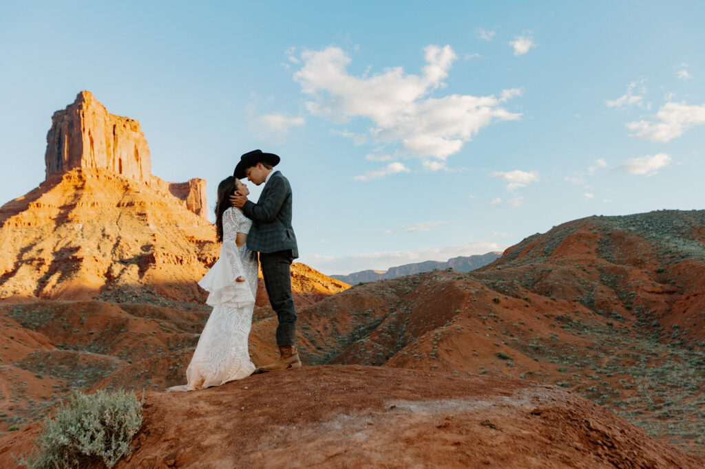 A groom gently touches the cheek of his bride during their Moab elopement