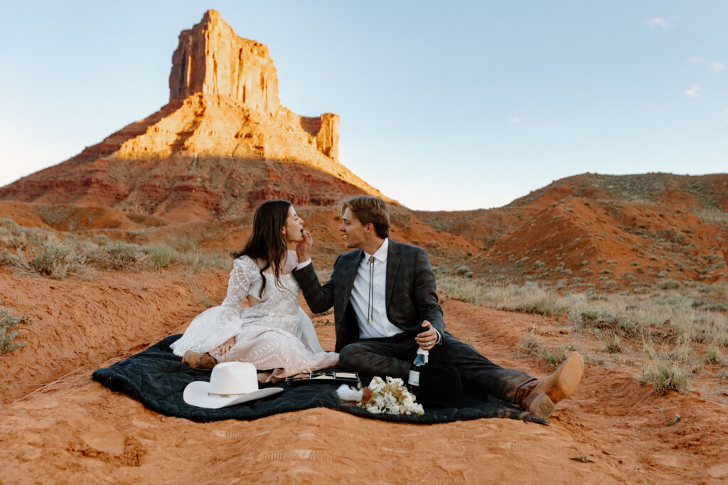 A couple set up a sweet picnic during their sunset elopement in Moab
