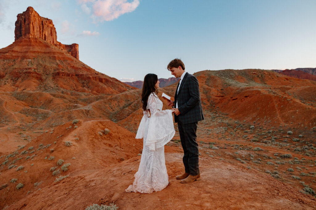 An eloping couple exchange vows at Ida Gulch at sunset in Moab Utah.