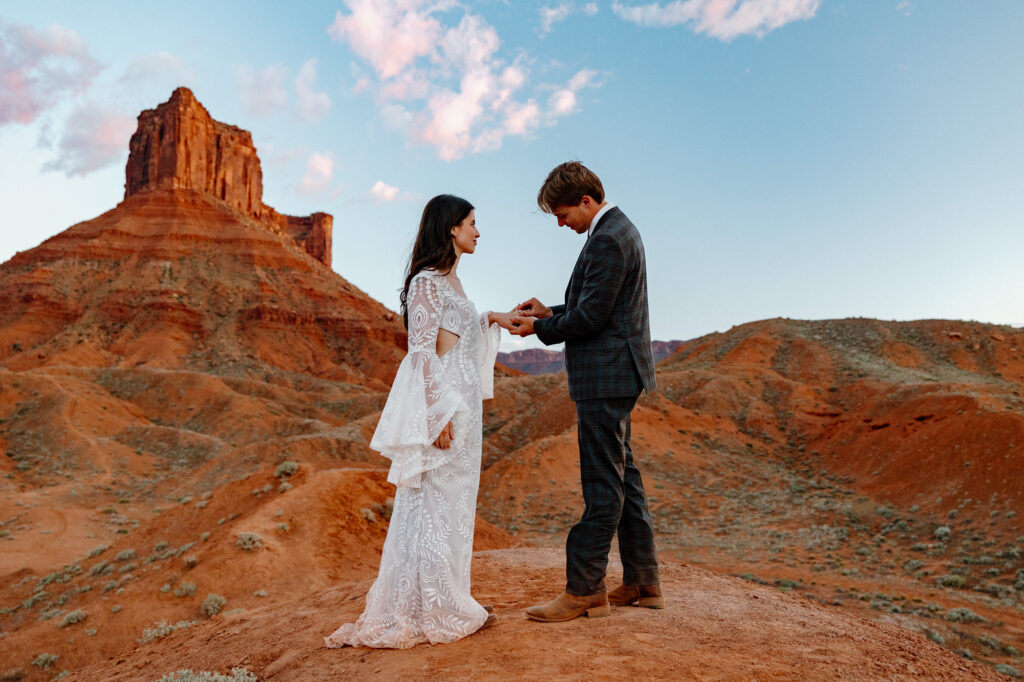 An eloping couple exchange rings at Ida Gulch at sunset in Moab Utah.